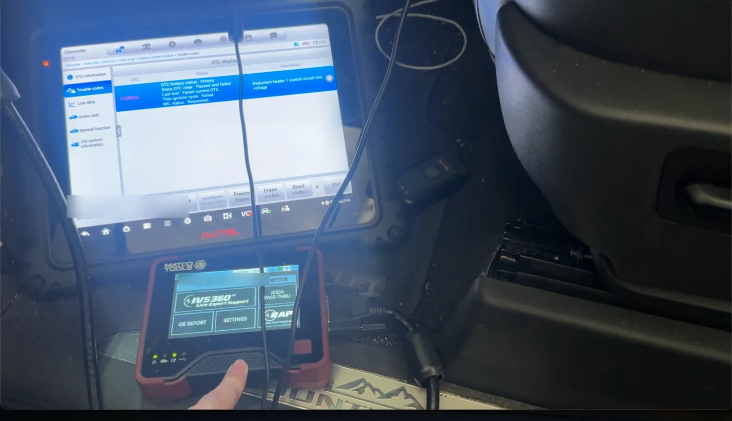 Autel scan tool showing diagnostic trouble code P20BB reductant heater 1 control circuit low voltage on a Chevrolet Silverado at RepairTech Automotive in Kissimmee, with a second tool connected below